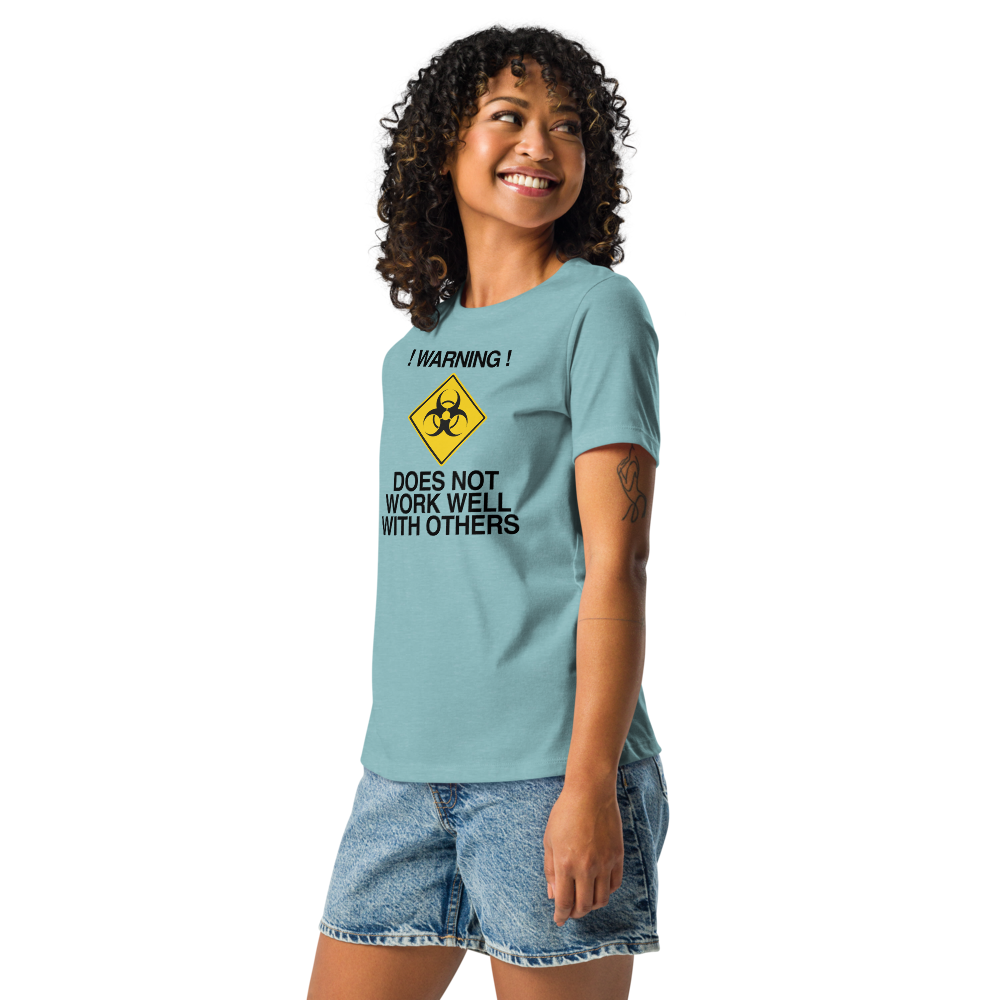 "!Warning! Does Not Work Well With Others" printed on a heather blue lagoon women's relaxed t-shirt worn by a female