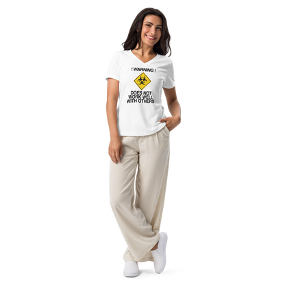 "!Warning! Does Not Work Well With Others" printed on a solid white blend women's relaxed v-neck t-shirt worn by a female