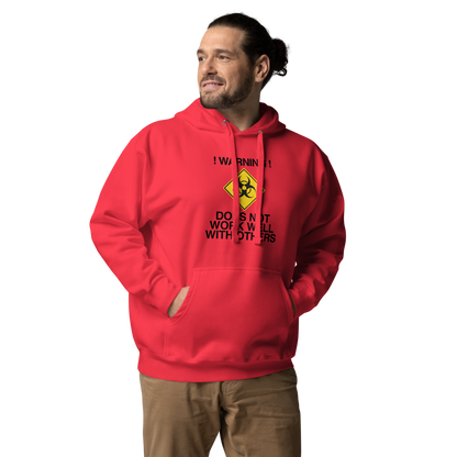 "!Warning! Does Not Work Well With Others" printed on a team red unisex hoodie worn by a male