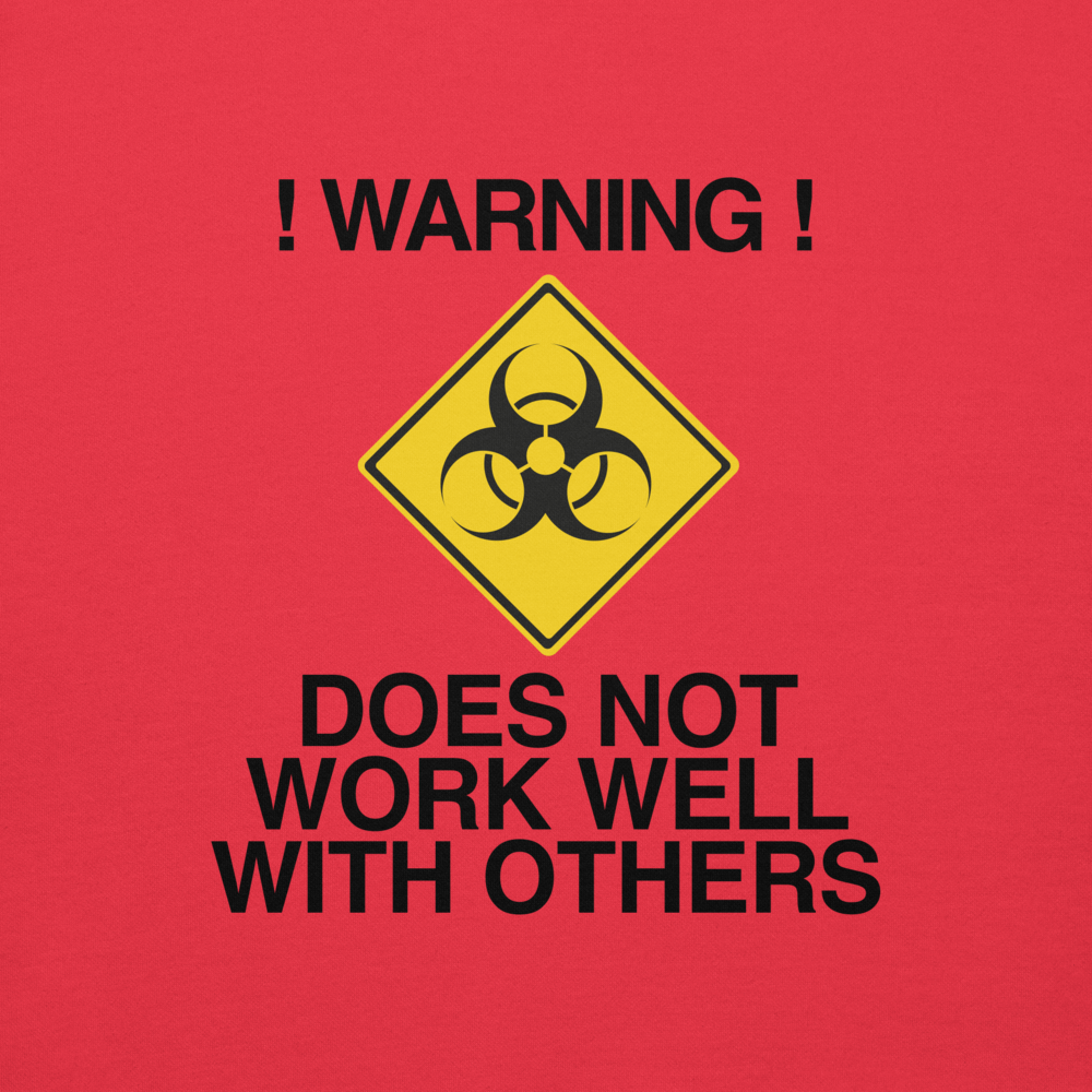 "!Warning! Does Not Work Well With Others" printed on a team red background