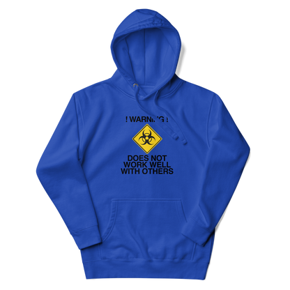"!Warning! Does Not Work Well With Others" printed on a team royal unisex hoodie laying on a flat surface with the hood up