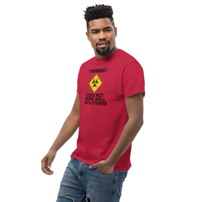 "!Warning! Does Not Work Well With Others" printed on a cardinal unisex classic tee worn by a male
