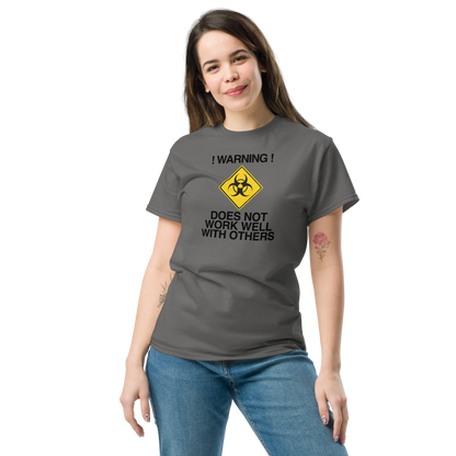 "!Warning! Does Not Work Well With Others" printed on a charcoal unisex classic tee worn by a female