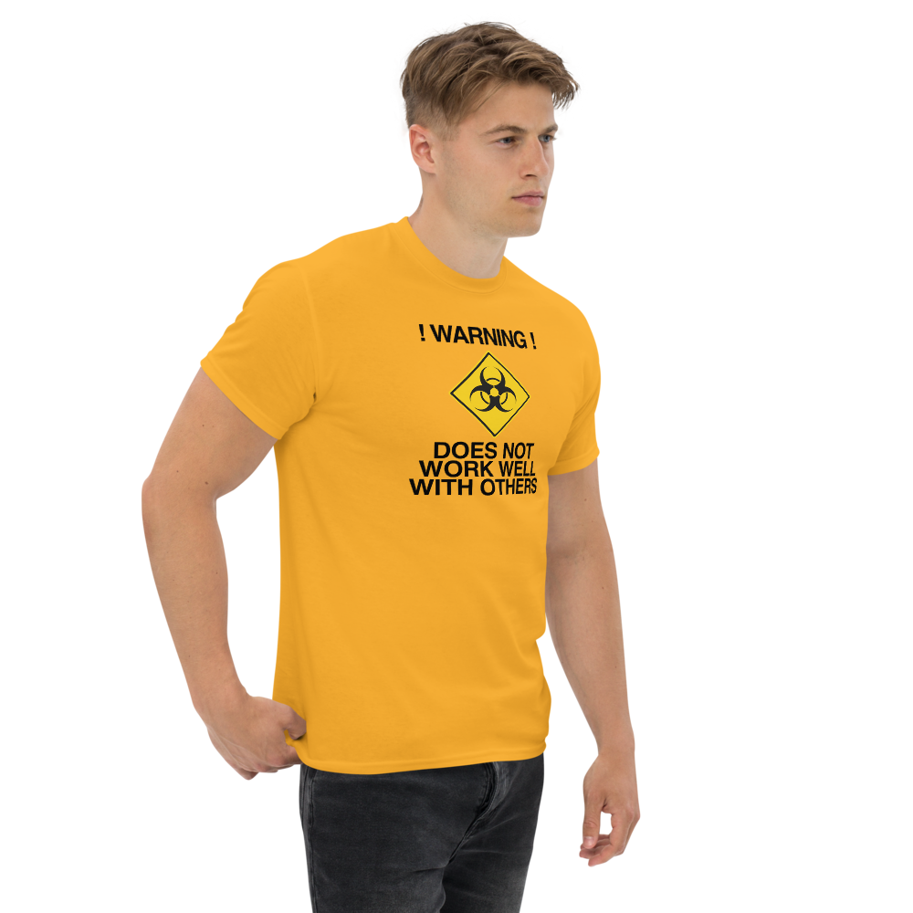 "!Warning! Does Not Work Well With Others" printed on a gold unisex classic tee worn by a male
