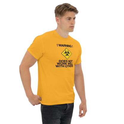 "!Warning! Does Not Work Well With Others" printed on a gold unisex classic tee worn by a male