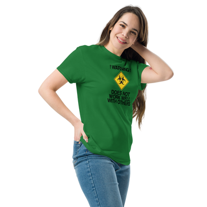 "!Warning! Does Not Work Well With Others" printed on a turf green unisex classic tee worn by a female