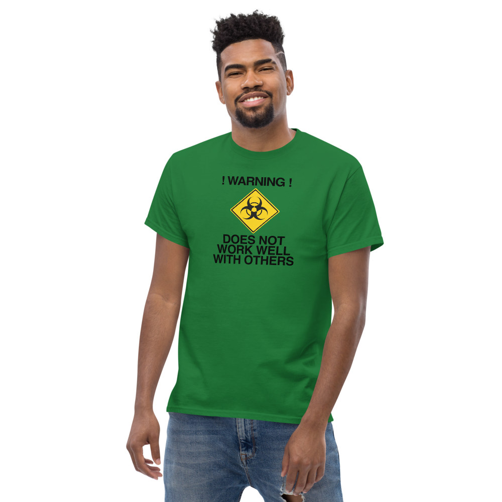 "!Warning! Does Not Work Well With Others" printed on a turf green unisex classic tee worn by a male