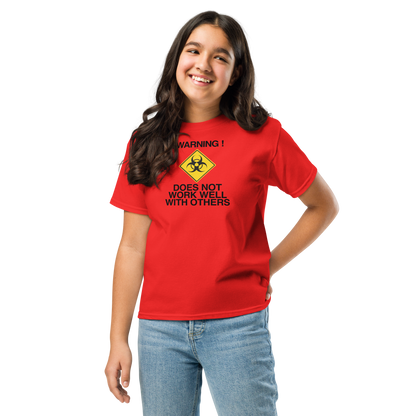 "!Warning! Does Not Work Well With Others" printed on a red youth classic tee worn by a female