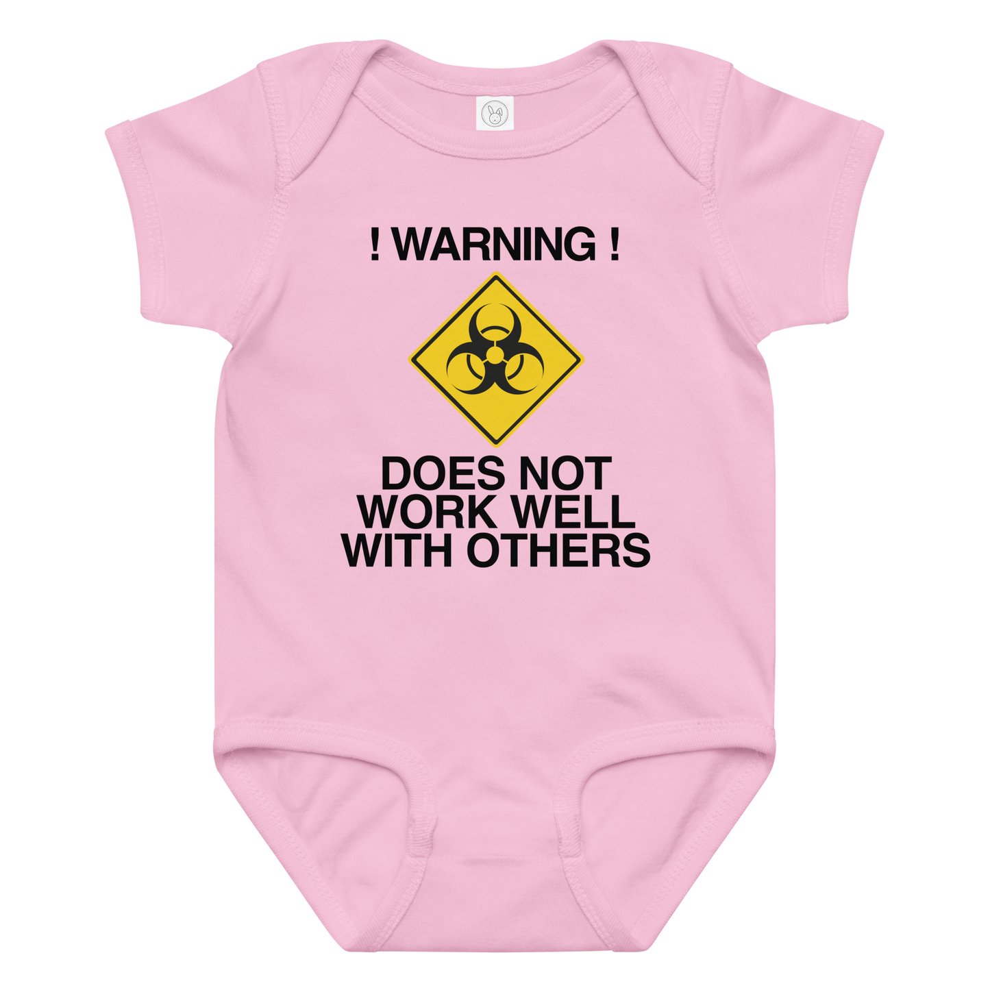 "!Warning! Does Not Work Well With Others" printed on a pink baby jersey bodysuit laying on a flat surface amongst other clothes