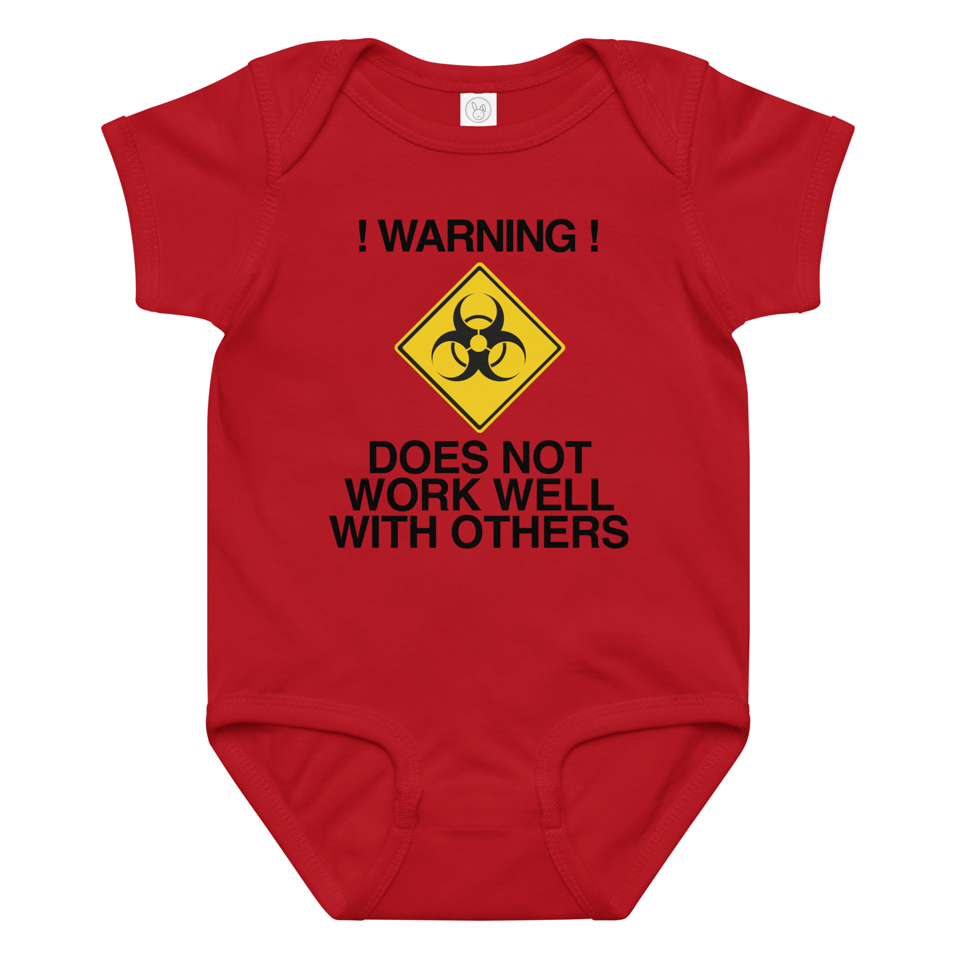 "!Warning! Does Not Work Well With Others" printed on a red baby jersey bodysuit laying on a flat surface amongst other clothes