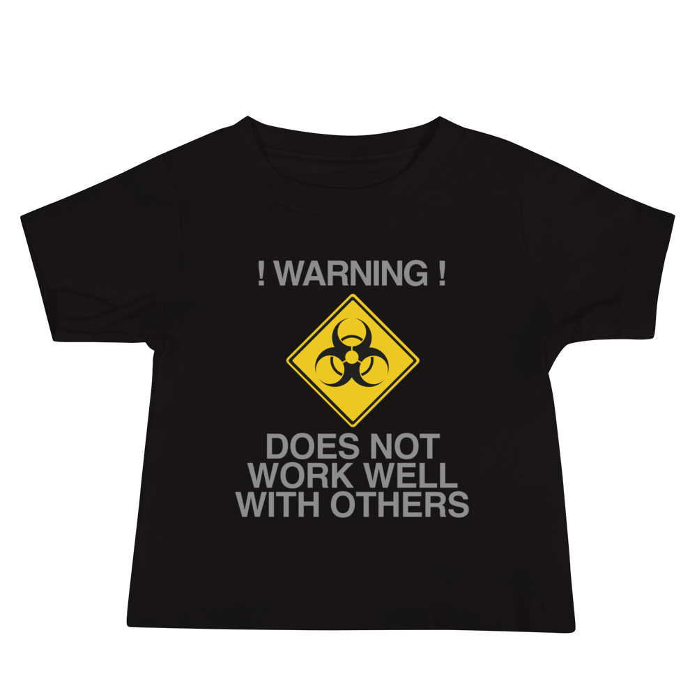 "!Warning! Does Not Work Well With Others" printed on a black baby jersey short sleeve tee laying on a flat surface