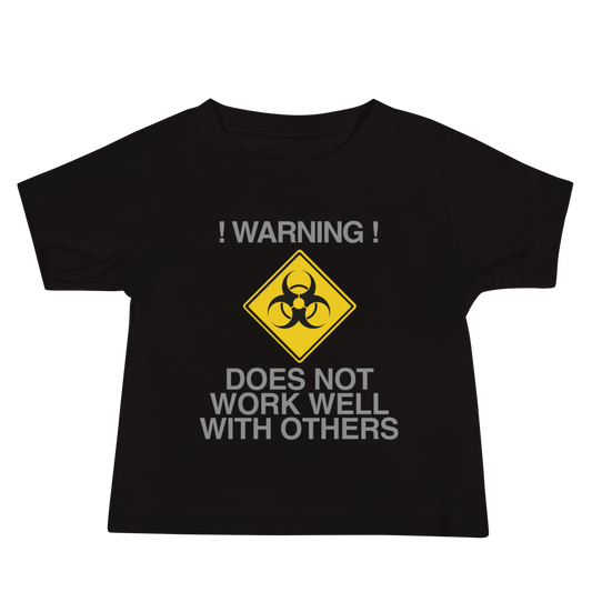 "!Warning! Does Not Work Well With Others" printed on a black baby jersey short sleeve tee laying on a flat surface