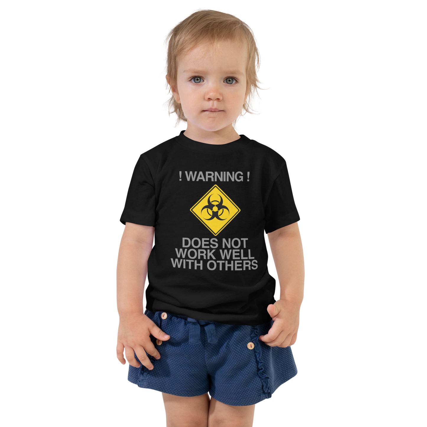 "!Warning! Does Not Work Well With Others" printed on a black toddler short sleeve tee worn by a female