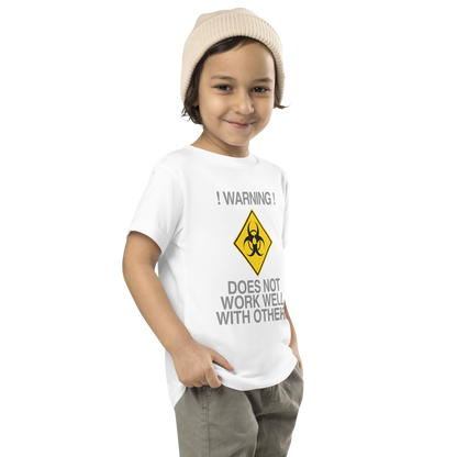 "!Warning! Does Not Work Well With Others" printed on a white toddler short sleeve tee worn by a male who is also wearing a knit cap