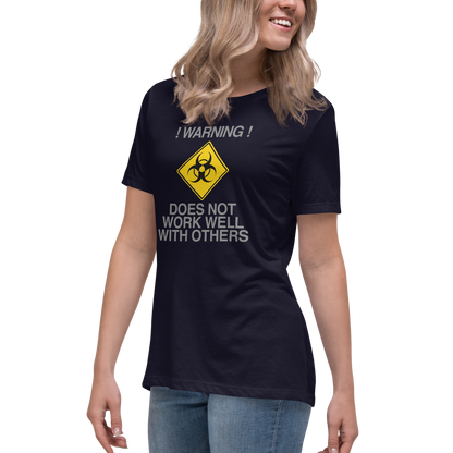 "!Warning! Does Not Work Well With Others" printed on a navy women's relaxed t-shirt worn by a female