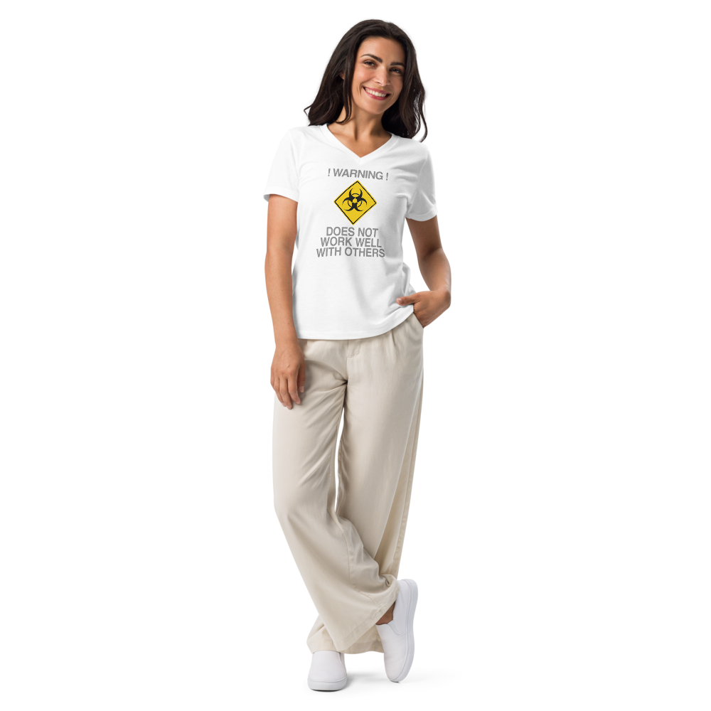 "!Warning! Does Not Work Well With Others" printed on a solid white blend women's relaxed v-neck t-shirt worn by a female