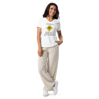 "!Warning! Does Not Work Well With Others" printed on a solid white blend women's relaxed v-neck t-shirt worn by a female