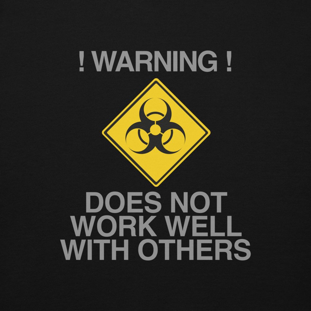 "!Warning! Does Not Work Well With Others" printed on a black background