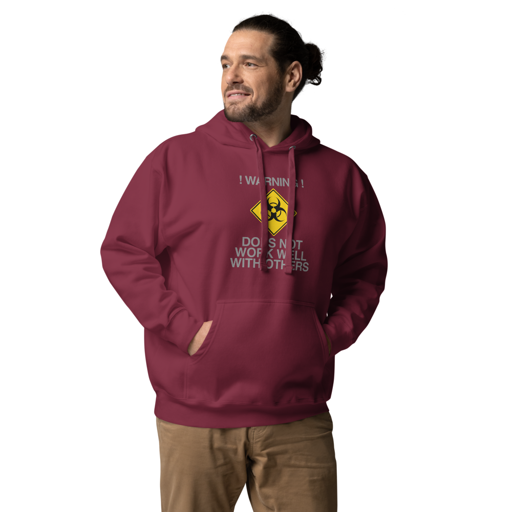 "!Warning! Does Not Work Well With Others" printed on a maroon unisex hoodie worn by a male