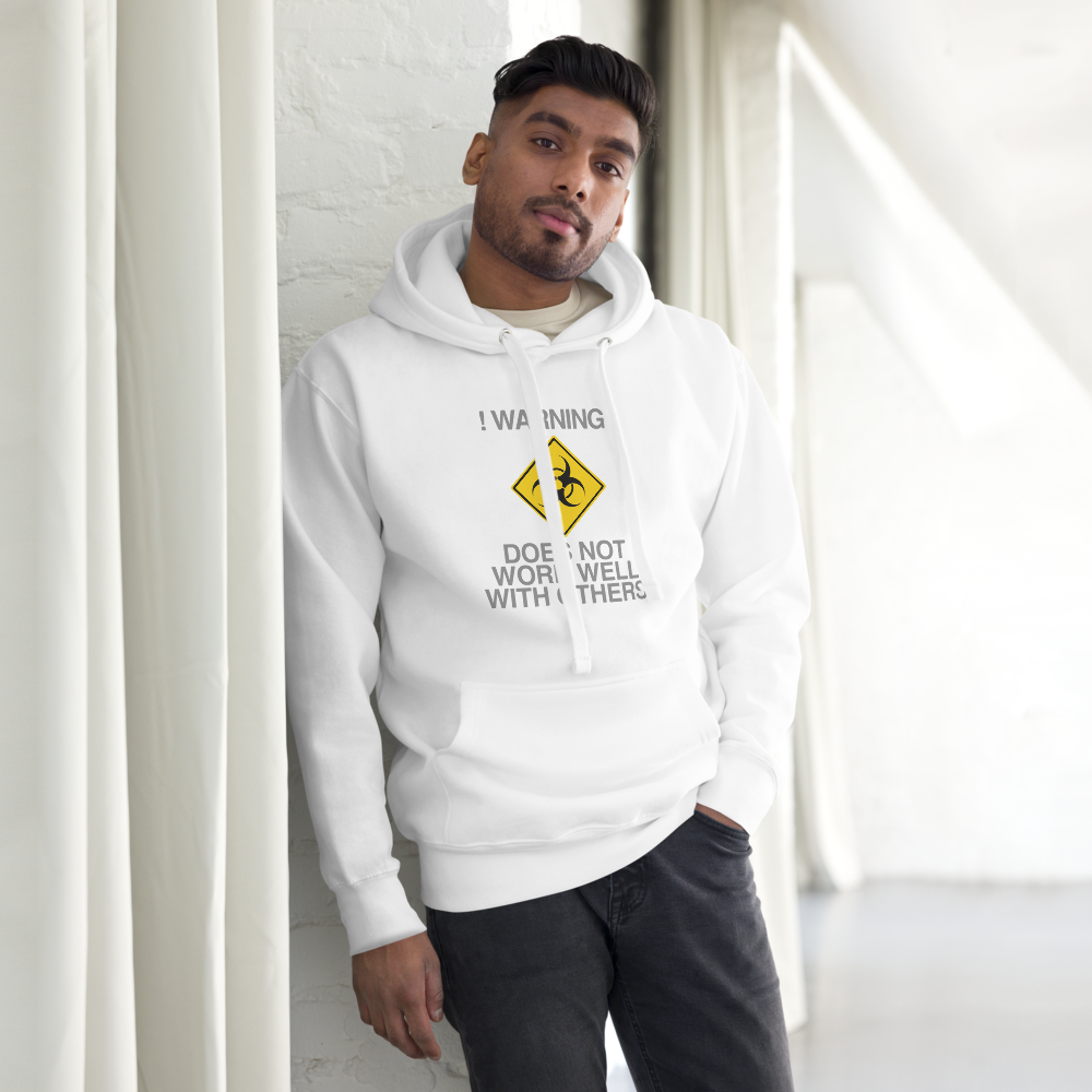 "!Warning! Does Not Work Well With Others" printed on a white unisex hoodie worn by a male