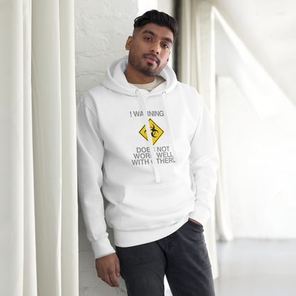 "!Warning! Does Not Work Well With Others" printed on a white unisex hoodie worn by a male