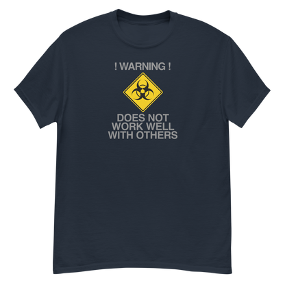 "!Warning! Does Not Work Well With Others" printed on a navy unisex classic tee laying on a flat surface