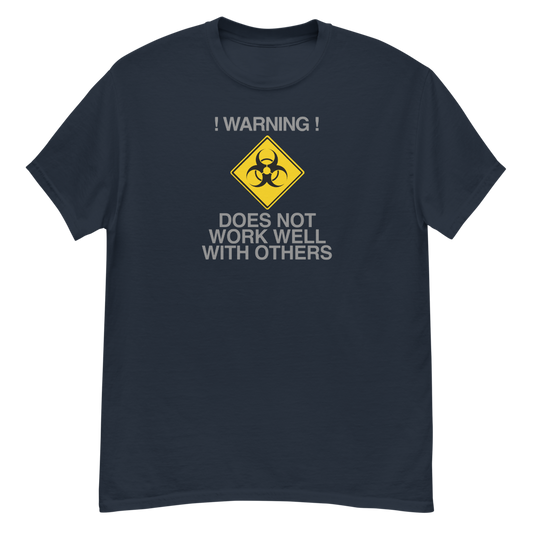 "!Warning! Does Not Work Well With Others" printed on a navy unisex classic tee laying on a flat surface