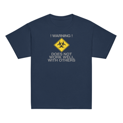 "!Warning! Does Not Work Well With Others" printed on a navy youth classic tee laying on a flat surface