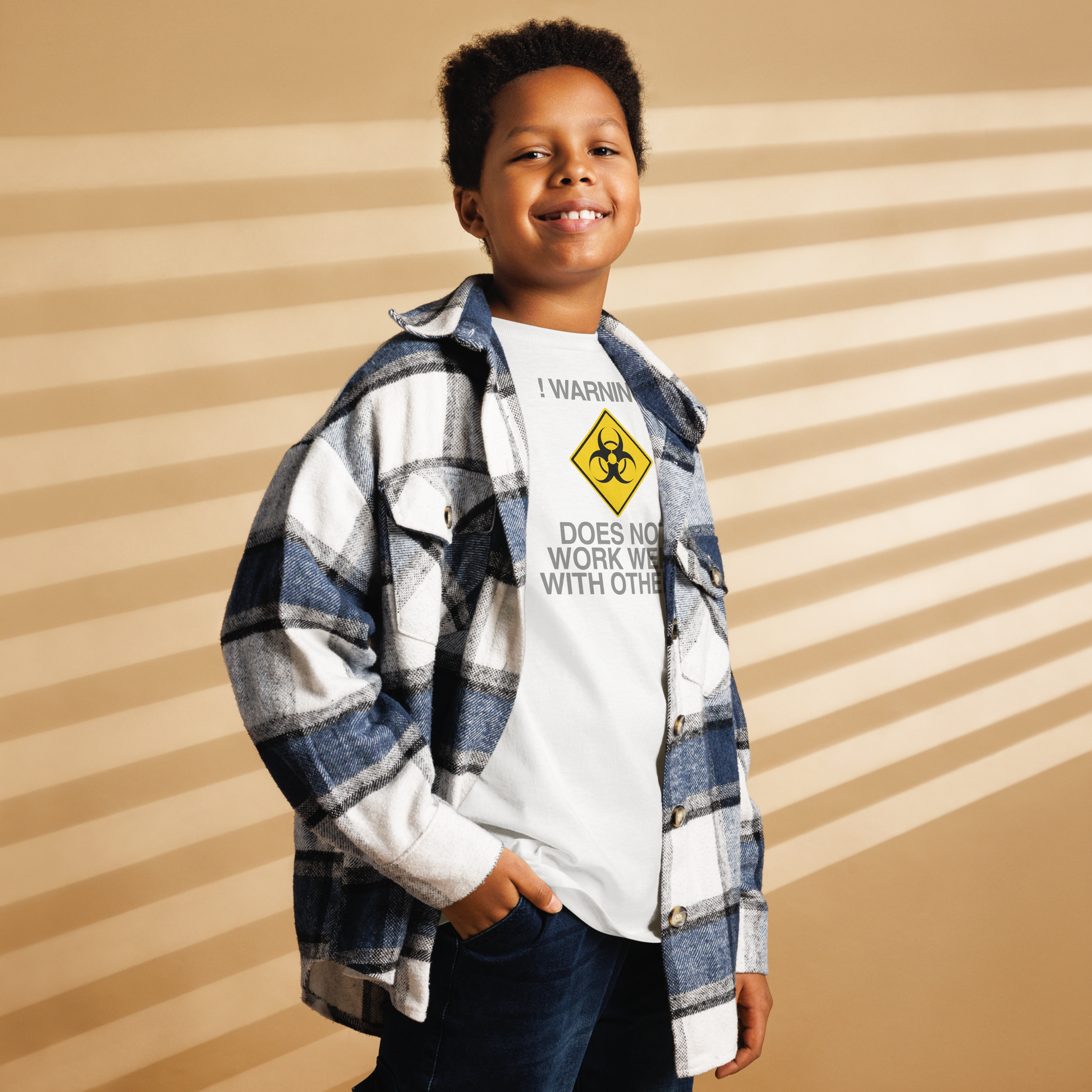 "!Warning! Does Not Work Well With Others" printed on a white youth classic tee worn by a male also wearing a jacket