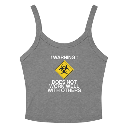 "!Warning! Does Not Work Well With Others" printed on a athletic heather women's micro-rib tanktop laying on a flat surface amongst sunglasses and shorts