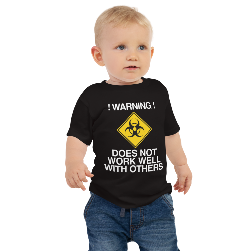 "!Warning! Does Not Work Well With Others" printed on a black baby jersey short sleeve tee worn by a male