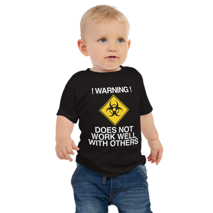 "!Warning! Does Not Work Well With Others" printed on a black baby jersey short sleeve tee worn by a male