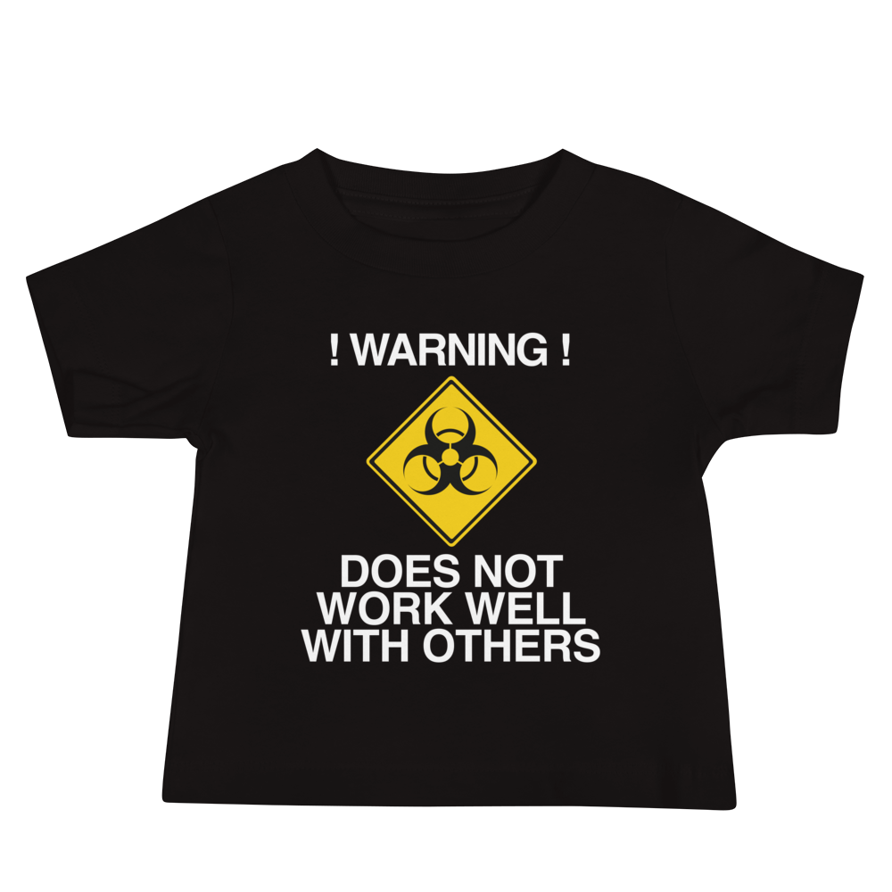 "!Warning! Does Not Work Well With Others" printed on a black baby jersey short sleeve tee laying on a flat surface