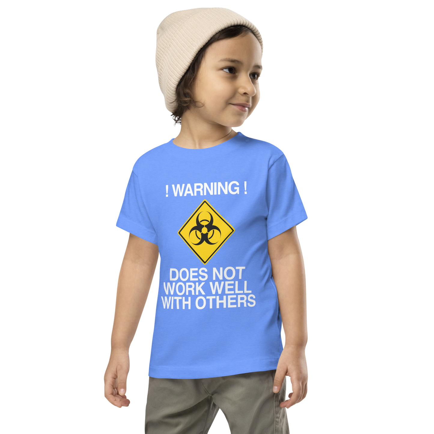 "!Warning! Does Not Work Well With Others" printed on a heather columbia blue toddler short sleeve tee worn by a male wearing a cap