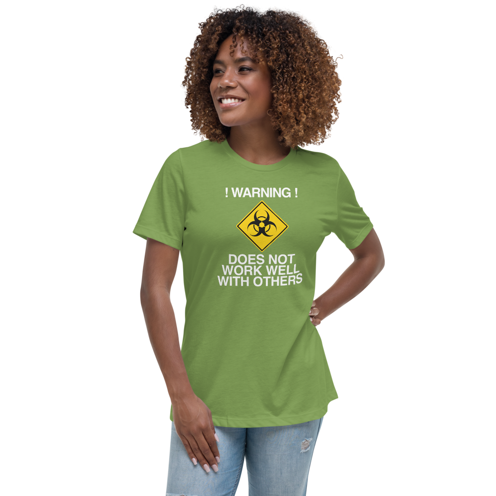"!Warning! Does Not Work Well With Others" printed on a leaf women's relaxed t-shirt worn by a female