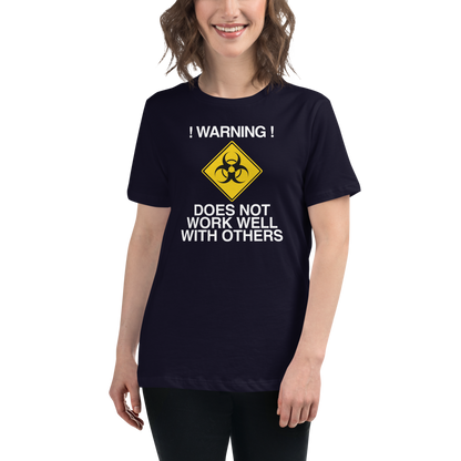 "!Warning! Does Not Work Well With Others" printed on a navy women's relaxed t-shirt worn by a female