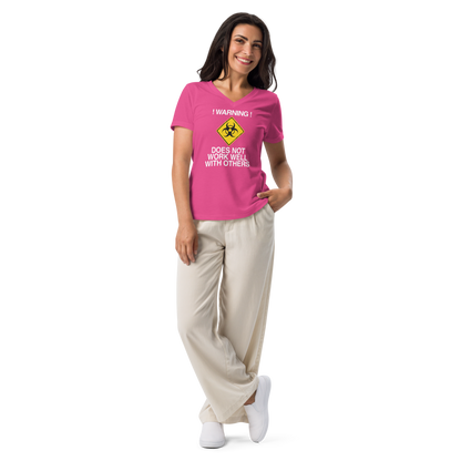 "!Warning! Does Not Work Well With Others" printed on a berry women's relaxed v-neck t-shirt worn by a female