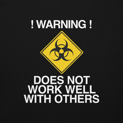 "!Warning! Does Not Work Well With Others" printed on a black background