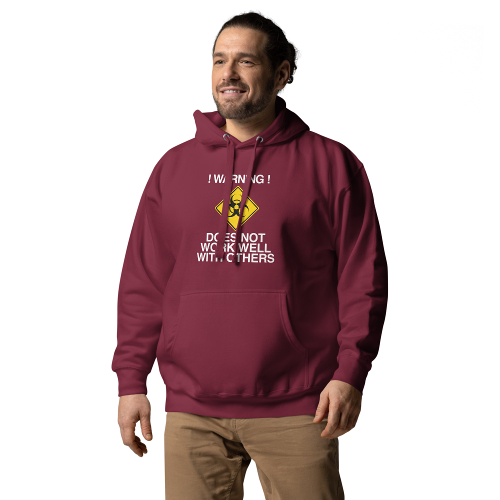 "!Warning! Does Not Work Well With Others" printed on a maroon unisex hoodie worn by a male