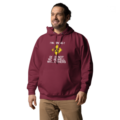 "!Warning! Does Not Work Well With Others" printed on a maroon unisex hoodie worn by a male