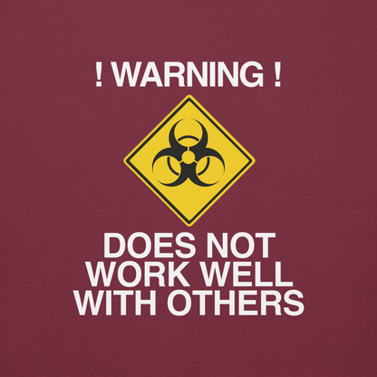 "!Warning! Does Not Work Well With Others" printed on a maroon background