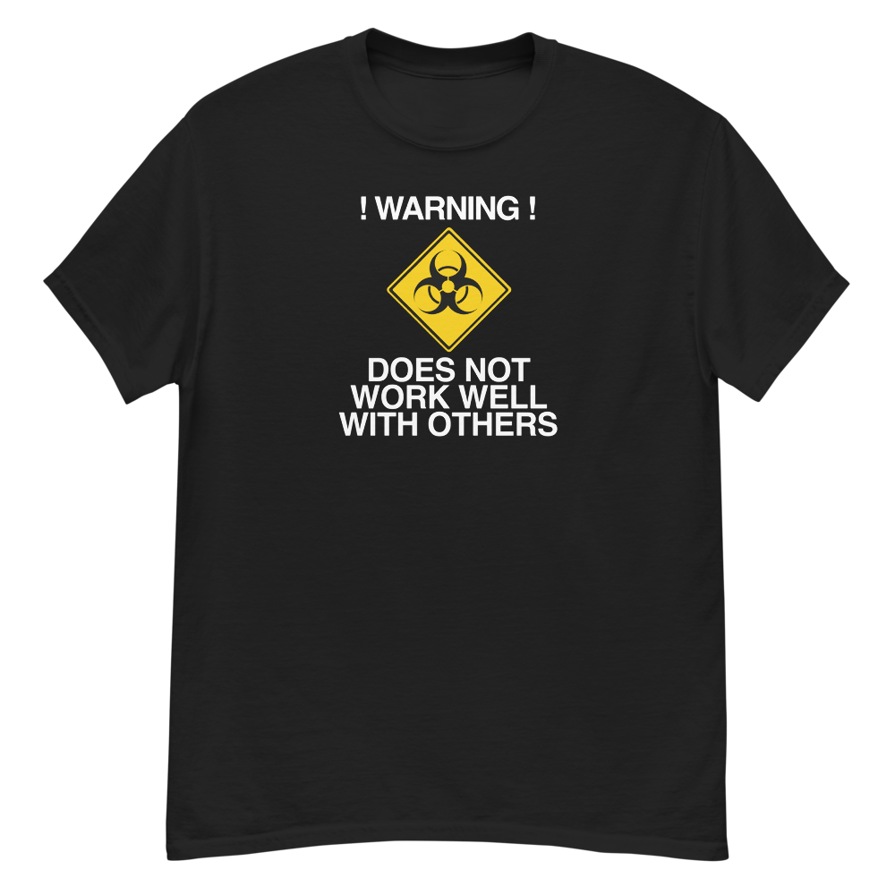 "!Warning! Does Not Work Well With Others" printed on a black unisex classic tee laying on a flat surface