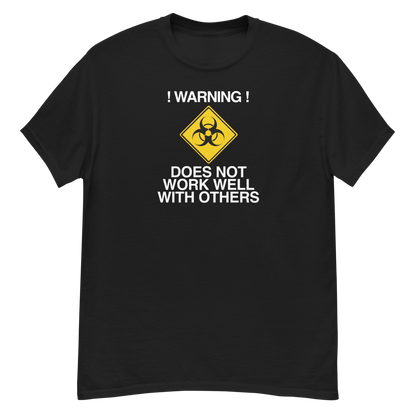"!Warning! Does Not Work Well With Others" printed on a black unisex classic tee laying on a flat surface