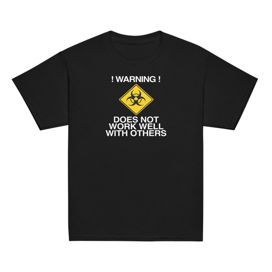 "!Warning! Does Not Work Well With Others" printed on a black youth classic tee laying on a flat surface