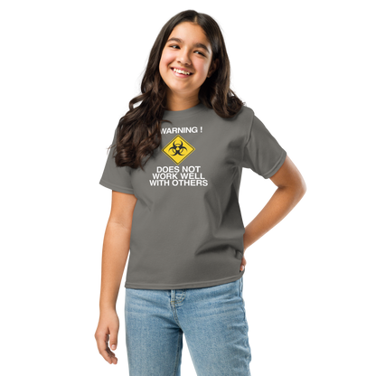 "!Warning! Does Not Work Well With Others" printed on a charcoal youth classic tee worn by a female