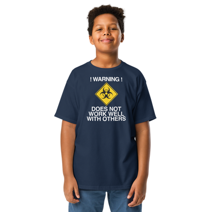 "!Warning! Does Not Work Well With Others" printed on a navy youth classic tee worn by a male