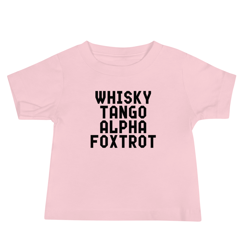 "Whisky Tango Alpha Foxtrot" printed on a pink baby jersey short sleeve tee laying on a flat surface