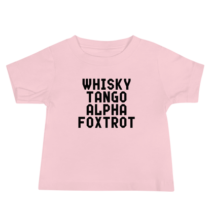 "Whisky Tango Alpha Foxtrot" printed on a pink baby jersey short sleeve tee laying on a flat surface