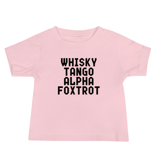 "Whisky Tango Alpha Foxtrot" printed on a pink baby jersey short sleeve tee laying on a flat surface