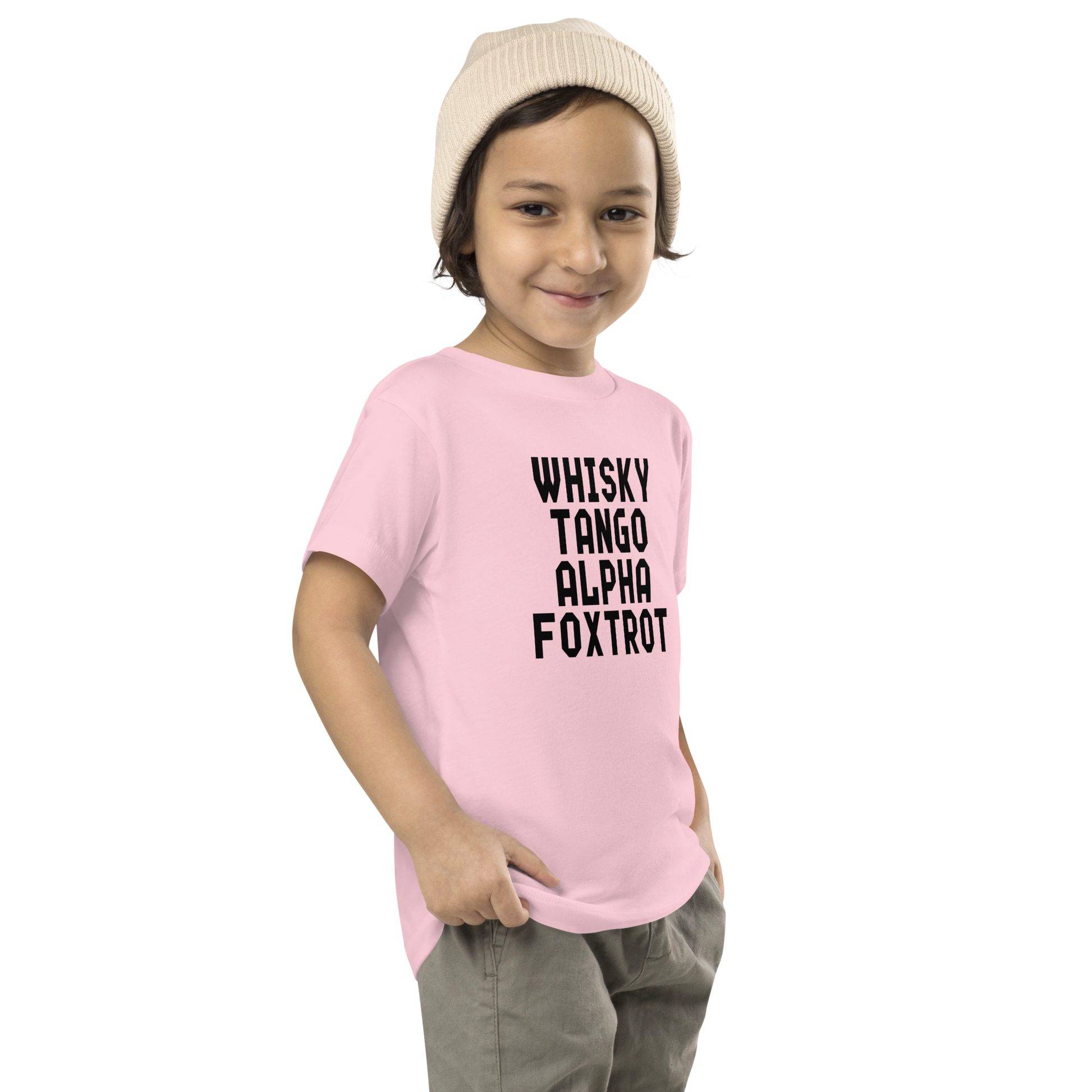 "Whisky Tango Alpha Foxtrot" printed on a pink toddler short sleeve tee worn by a male who is also wearing a knit cap
